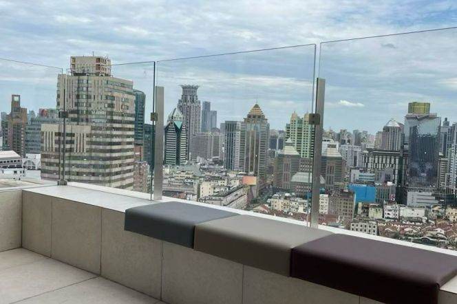 Top-floor duplex on Suzhou River, with a private large terrace and a high-ceilinged living room.